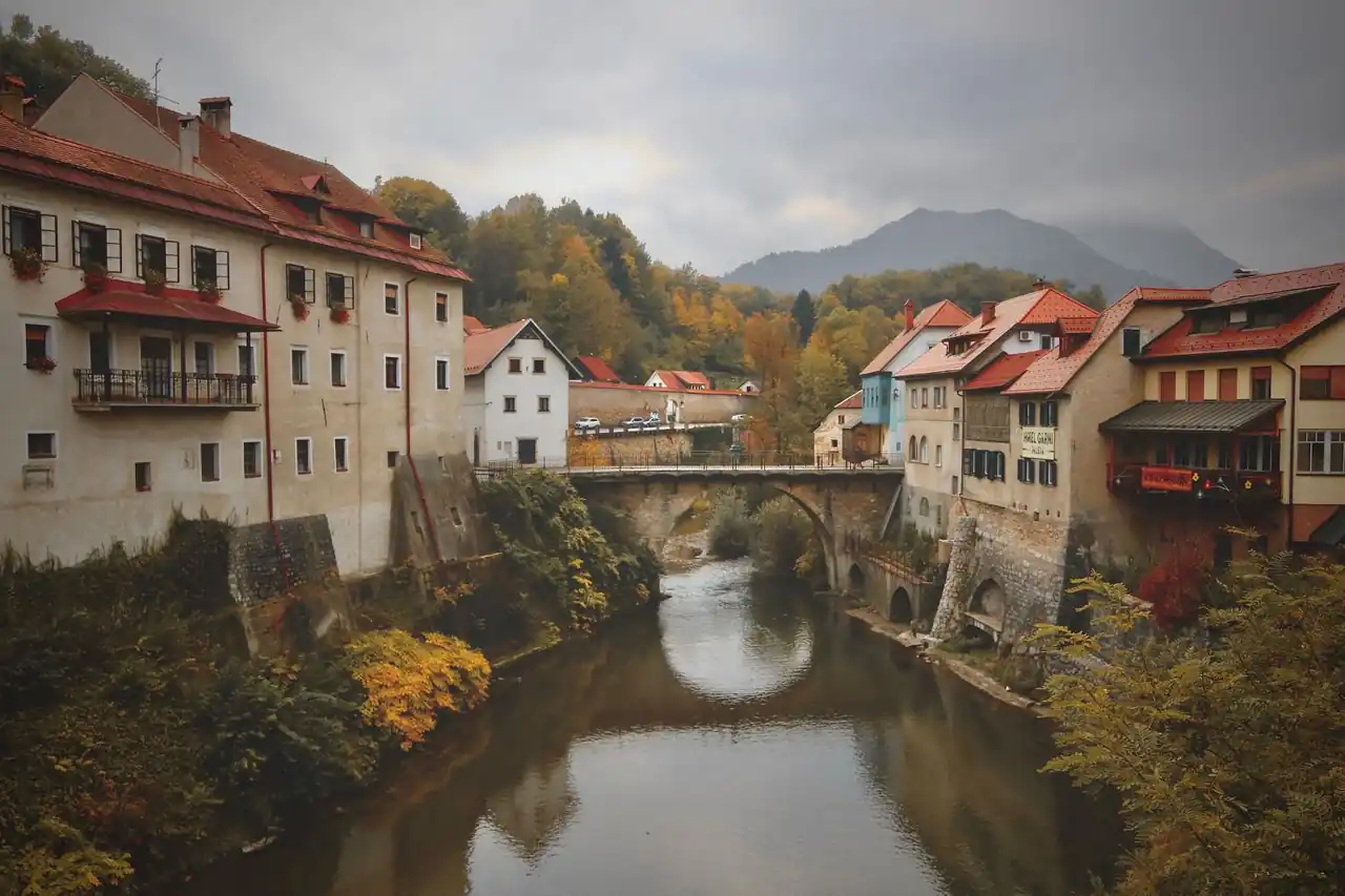 Zgodovinska arhitektura in rečni most v jesenskem vzdušju